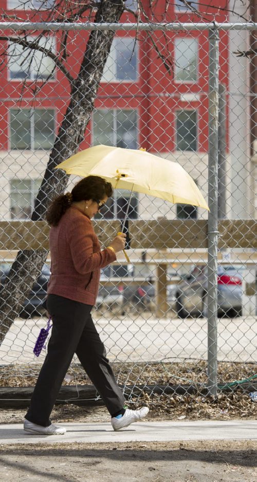 140505 Winnipeg - DAVID LIPNOWSKI / WINNIPEG FREE PRESS (May 05, 2014)  A woman walks with an umbrella Monday afternoon downtown.