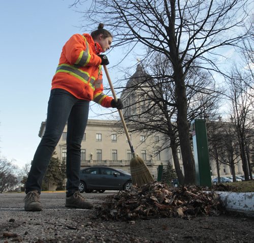 Kristina Komoly working for the summer in the Manitoba gov't greenhouse helps tidy up the Manitoba Legislative building grounds Friday morning. For weather story Wayne Glowacki / Winnipeg Free Press May 9 2014