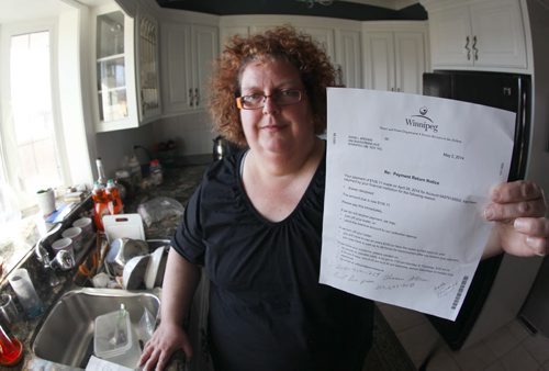 Dana Brenan with letter from city threatening to cut off her water and send bill to collection agency  She is still getting the bill in her mother Heathers name 2 years after her death-See  Carol Sanders story- May 09, 2014   (JOE BRYKSA / WINNIPEG FREE PRESS)