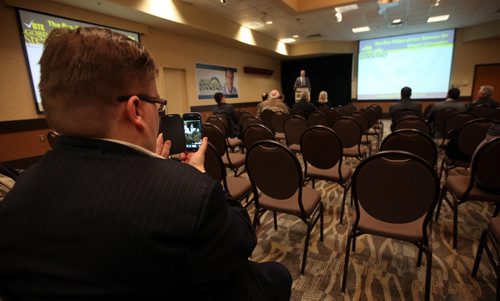 A particpant in the back row of a mostly empty meeting room takes a video of Gord Steeves Monday evening. See Geoff Kirbyson story. May 12, 2014 - (Phil Hossack / Winnipeg Free Press)