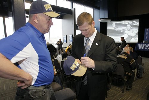May 12, 2014 - 140512  - Mike O'Shea Winnipeg Blue Bomber head coach signs a hat for Bomber alumnus Mike Hameluck at Fan Fare at Investors Group Field  Monday, May 12, 2014.  John Woods / Winnipeg Free Press