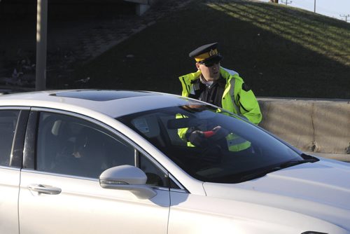 IMAGE BLURRED TO PROTECT IDENTITY  Caption: Const. Justin Boileau speaks with one of several motorists RCMP pull over on the Perimeter Highway on a Friday evening. "They'll come down over the hilltop and we'll just get 'em," he says. RCMP ride-along  May 9, 2014  James Turner/Winnipeg Free Press