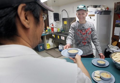 Crossways in Common (222 Furby St )  volunteer Kelly Ross serves food from kitchen See  Aaron Epp story- May 14, 2014   (JOE BRYKSA / WINNIPEG FREE PRESS)