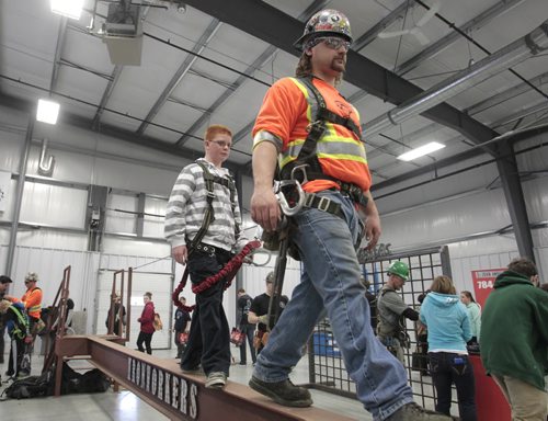 Stefan Froese, a grade 8 student from Mitchell Middle School wears a safety harness and walks on a beam with iron worker Kody Morten. About 1800 students attended the 6th annual Manitoba Construction Career Expo held at the Red River Exhibition Place. Students had an opportunity to try their hand at construction-related trades (welding, painting, roofing, piping ect.) at 34 interactive booths/displays.  see release Wayne Glowacki / Winnipeg Free Press May 14 2014