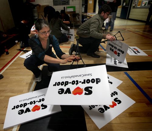 Organizers assemble lawn signs Wednesday evening to keep door to door postal delivery at an informational meeting held at Maples Collegiate. Geoff Kirbyson story. May 14, 2014 - (Phil Hossack / Winnipeg Free Press)