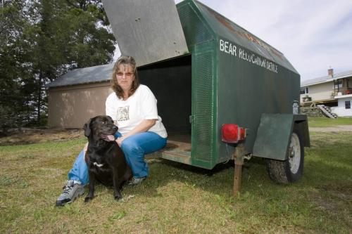 KENORA - Sherry Fisher sits with her own dog on the edge of the trap the City of Kenora has provided her to trap wild dogs on her property.  Tom Thomsom for Winnipeg Free Press