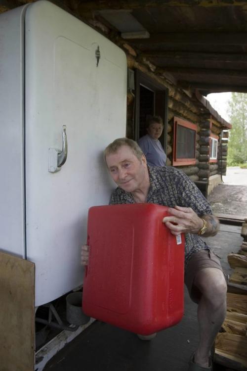 RED DEER KAKE - Steve fills up the fridge that runs on kerosene in his 1913 cottage.  Tom Thomsom for Winnipeg Free Press