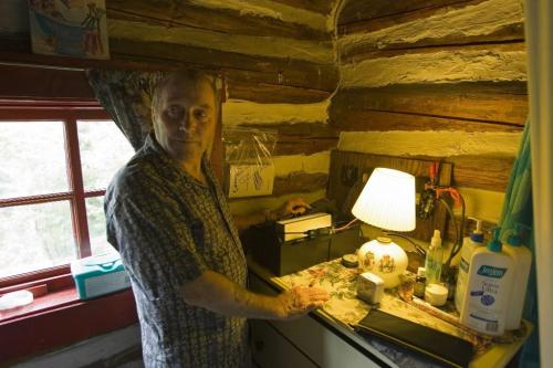 RED DEER KAKE - Cottager Steve Needham works the phone that operates on solar power, and requires a 20-foot aerial on top of the cottage. Tom Thomsom for Winnipeg Free Press