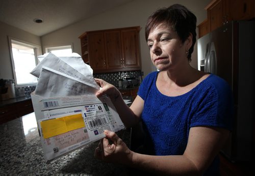 Diana Barnowich holds up envelopes which her mom stuffed cash then put envelope inside envelope before mailing the stash to fraudsters.  (NOTE: her mom's adress is taped over only leaving the fraudster's adress on the envelopes) Diana's quick actions stopped her 76-year-old mom, who has dementia, from giving away over $14,000 and becoming a victim of a telephone Jamaican lottery scam. The mom had just mailed $2,500 in cash, after previously sending cheques totalling $8,300. The daughter was able to get the envelope containing the cash back from the postal outlet before it was sent and stopped payment on the cheques. The fraudsters had disconnected her mom's phone number through MTS and changed it to a phone number just they had. Diana confronted two different men on the phone and traced one of the people the money was being sent to. There were people with a Jamaican phone number and people in Los Angeles, Pinehill Wyoming and Surrey, B.C. involved. She reported it to the RCMP and Canadian Anti-Fraud Agency. May 16, 2015 - (Phil Hossack / Winnipeg Free Press)