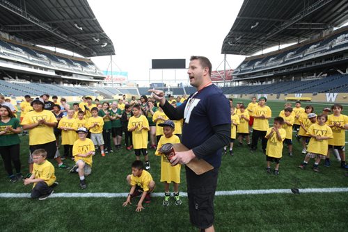 Doug Brown directs the  kids to the different drill stations at Investors Group Field Saturday morning during KidSport  Football Camp which teaches kids  the fundamentals of football.  Standup photo May 17, 2014 Ruth Bonneville / Winnipeg Free Press