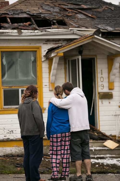 Residents of a fire damaged home on Jefferson Avenue near Scotia Street react to seeing the aftermath Monday morning. Bradley Larocque (in black) noticed someone running from a house next door before 8am, and then heard a "whoosh" as fire engulfed the home that was under construction. He got all six other residents out of the house before there were any injuries. Three of five cats were rescued, and another was seen escaping. In total four houses were damaged, fire and police continue to investigate.  140519 - Monday, May 19, 2014 - (Melissa Tait / Winnipeg Free Press)