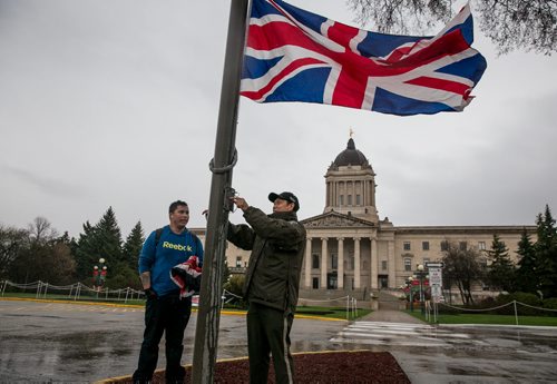 The Union Jack is raised at the Manitoba Legislature by protection services officer Eustaquio Tadeo, with help from Tyler MacMartin, in advance of Prince Charles and his wife Camilla, Duchess of Cornwall's, visit to Winnipeg on Wednesday.   140519 - Monday, May 19, 2014 - (Melissa Tait / Winnipeg Free Press)