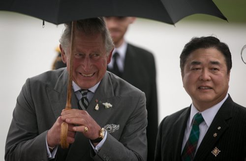 Prince Charles laughs with Lt. Gov. Philip Lee after a wet and windy arrival on the tarmac at CFB Winnipeg Tuesday evening. The royal couple will visit Winnipeg for 27 hours. 140520 - Tuesday, May 20, 2014 - (Melissa Tait / Winnipeg Free Press)
