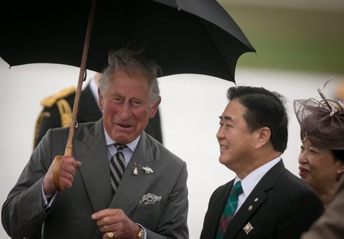 Prince Charles laughs with Lt. Gov. Philip Lee after a wet and windy arrival on the tarmac at CFB Winnipeg Tuesday evening. The royal couple will visit Winnipeg for 27 hours. 140520 - Tuesday, May 20, 2014 - (Melissa Tait / Winnipeg Free Press)