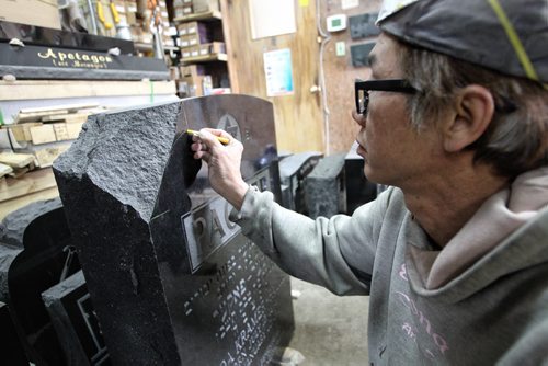 Binh Huyhn the stonemason at Everlasting Memorials sketches out where he will modify the damaged headstone so it will look brand new. They spent the morning fixing the other 14 stones on site at the Jewish cemetery vandalized last week. 140521 May 21, 2014 Mike Deal / Winnipeg Free Press