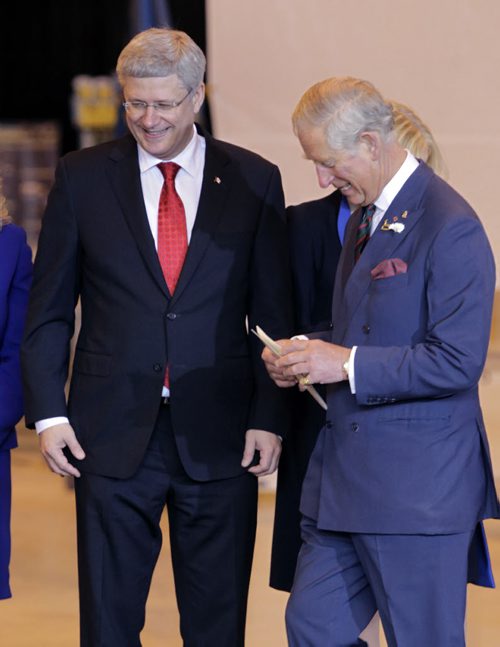 At left, Prime Minister Stephen Harper invites Prince Charles to the podium at the ceremony in the Stevenson Hangar Wednesday morning.   Wayne Glowacki / Winnipeg Free Press May 21 2014