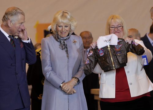 At right, Barb Bowen presents Prince Charles and Camilla, Duchess of Cornwall a flight jacket for Prince George at the ceremony in the Stevenson Hangar Wednesday morning.   Wayne Glowacki / Winnipeg Free Press May 21 2014