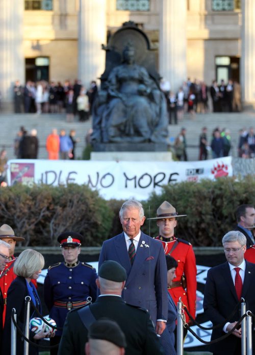 Prince Charles received full military honors while an Idle no More banner framed the party before departing Winnipeg Wednesday evening. May 21, 2014 - (Phil Hossack / Winnipeg Free Press)