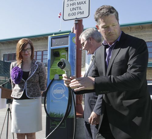 From right, Tim Scott, with CAA-Manitoba, Municipal Government Minister Stan Struthers, Minister responsible for Manitoba Hydro and Clare MacKay with The Forks North Portage at the unveiling ceremony Thursday morning of the first electric-vehicle charging station that is located in the parking lot on the north side of The Forks.     Larry Kusch Story.Wayne Glowacki / Winnipeg Free Press May 22 2014