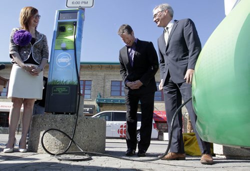 From right, Municipal Government Minister Stan Struthers, Minister responsible for Manitoba Hydro ,Tim Scott, with CAA-Manitoba and Clare MacKay with The Forks North Portage by an electric car at the unveiling ceremony Thursday morning of the first electric-vehicle charging station that is located in the parking lot on the north side of The Forks.     Larry Kusch Story.Wayne Glowacki / Winnipeg Free Press May 22 2014
