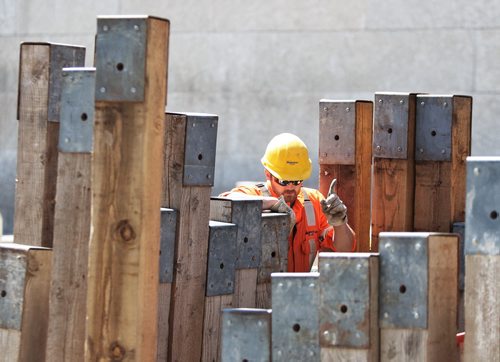 A Manitoba Hydro employee looks into the construction pit that is causing the redirection of traffic on Memorial Blvd Thursday afternoon.  140522 May 22, 2014 Mike Deal / Winnipeg Free Press