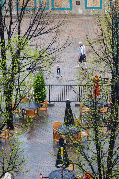20140525 - Steve Bryk and 18 month old Grandson Carter Oswald pass by an empty patio at the Forks Sunday morning. Darcy Finley / Winnipeg Free Press
