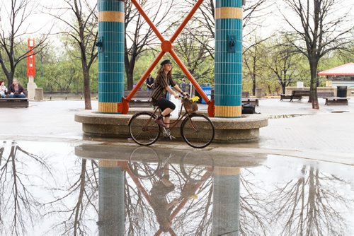20140525 - Kristen Andrews rides her bike by a giant puddle at the Fork Sunday Morning. Darcy Finley / Winnipeg Free Press