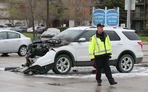 Police work at the scene of a two-vehicle collision during the afternoon on Sun., May 25, 2014, at the intersection of Beaverhill Boulevard and Fermor Avenue. A white SVU was badly damaged and burned while a sedan was also involved. Photo by Jason Halstead/Winnipeg Free Press