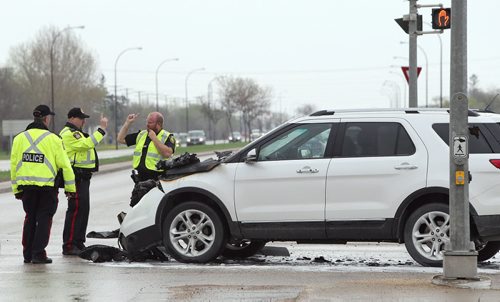 Police work at the scene of a two-vehicle collision during the afternoon on Sun., May 25, 2014, at the intersection of Beaverhill Boulevard and Fermor Avenue. A white SVU was badly damaged and burned while a sedan was also involved. Photo by Jason Halstead/Winnipeg Free Press