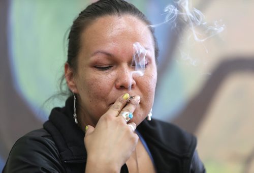 Medical marijuana patient Lee-Anne Kent smokes at the Medical Marijuana Lounge and Resource Centre at Vapes on Main on Mon., May 26, 2014. Former police officer Bill VanderGraaf and two partners have opened up a lounge for medical marijuana users at 1402 Main St. RE: Larry Kusch story Photo by Jason Halstead/Winnipeg Free Press