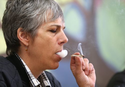 Medical marijuana patient Holly Plouffe smokes at the Medical Marijuana Lounge and Resource Centre at Vapes on Main on Mon., May 26, 2014. Former police officer Bill VanderGraaf and two partners have opened up a lounge for medical marijuana users at 1402 Main St. RE: Larry Kusch story Photo by Jason Halstead/Winnipeg Free Press