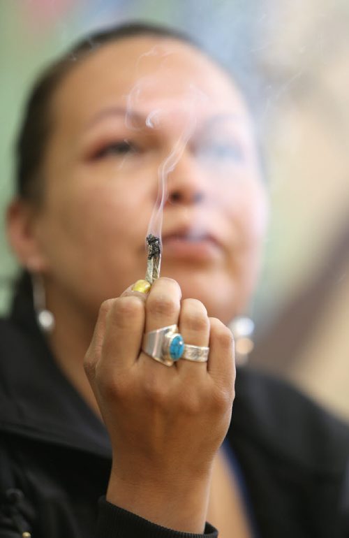 Medical marijuana patient Lee-Anne Kent smokes at the Medical Marijuana Lounge and Resource Centre at Vapes on Main on Mon., May 26, 2014. Former police officer Bill VanderGraaf and two partners have opened up a lounge for medical marijuana users at 1402 Main St. RE: Larry Kusch story Photo by Jason Halstead/Winnipeg Free Press