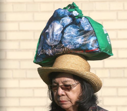A woman who identified herself as Carolina carries her groceries home on her head Wednesday morning at Lipton St and Notre Dame Ave  Standup photo- May 28, 2014   (JOE BRYKSA / WINNIPEG FREE PRESS)
