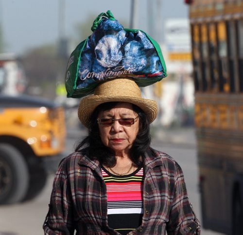 A woman who identified herself as Carolina carries her groceries home on her head Wednesday morning at Lipton St and Notre Dame Ave  Standup photo- May 28, 2014   (JOE BRYKSA / WINNIPEG FREE PRESS)