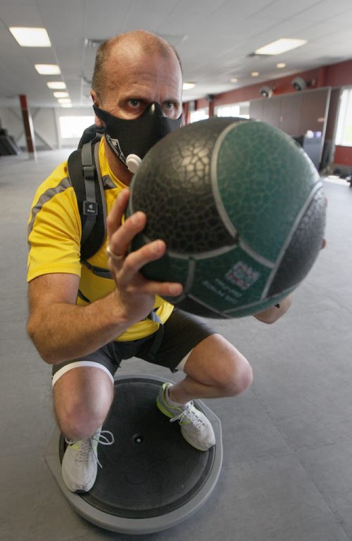 Ian Fish on a bosu ball wearing his elevation mask and a backpack with 45 lbs while training at Goodlife on Keneston Blvd.- Ian  has lung disease; his lungs only deliver 60 per cent of the oxygen they should. He recently lost 50 pounds through healthy eating and exercise. Now he's training to climb a mountain in Alberta. His third and most dangerous climb yet will raise money for the Lung Association, specifically programs that promote health and exercise to lung disease patients. - see Shamona Harnett story- May 28, 2014   (JOE BRYKSA / WINNIPEG FREE PRESS)