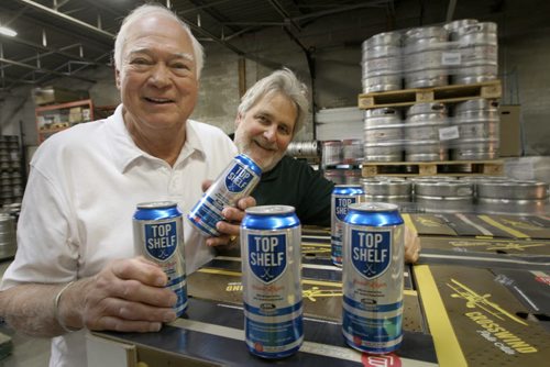 The NHL Alumni Association is launching Top Shelf Classic Lager through WETT Sales & Distribution in Winnipeg as of Monday. A portion of the proceeds of sales will go towards supporting retired hockey players who never hit the big payday .Bill Gould, president of WETT Sales, and Ab McDonald, first captain of the WHA Winnipeg Jets, left - Geoff Krybson story- May 29, 2014   (JOE BRYKSA / WINNIPEG FREE PRESS)