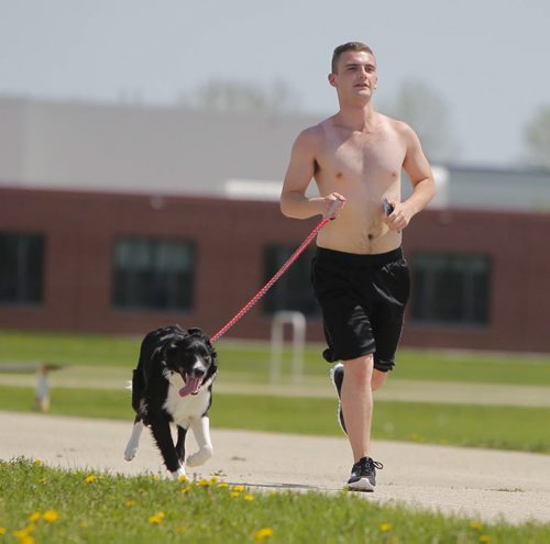 STANDUP - WEATHER - Kyle Goertzen runs his boarder collie names Chill on the Sisler Highschool track Thursday afternoon in the blazing sun. He said the dog love the run every day. He goes for about and hour. BORIS MINKEVICH / WINNIPEG FREE PRESS  May 29, 2014