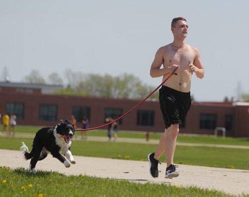 STANDUP - WEATHER - Kyle Goertzen runs his boarder collie names Chill on the Sisler Highschool track Thursday afternoon in the blazing sun. He said the dog love the run every day. He goes for about and hour. BORIS MINKEVICH / WINNIPEG FREE PRESS  May 29, 2014