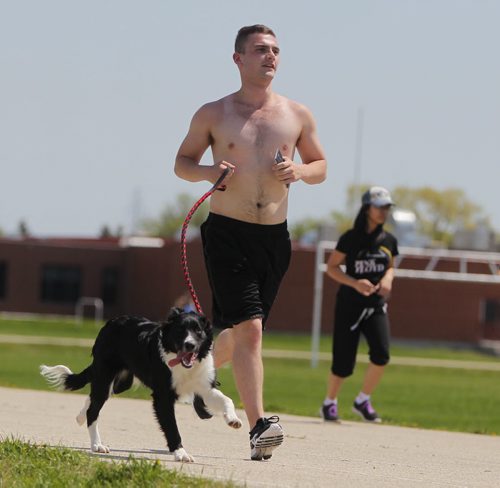 STANDUP - WEATHER - Kyle Goertzen runs his boarder collie names Chill on the Sisler Highschool track Thursday afternoon in the blazing sun. He said the dog love the run every day. He goes for about and hour. BORIS MINKEVICH / WINNIPEG FREE PRESS  May 29, 2014