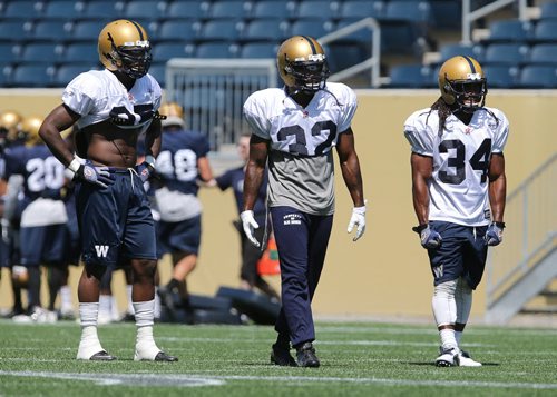 From left, Winnipeg Blue Bombers running back hopefuls Kevin Smith, Nic Grigsby and Paris Cotton during football practice at Investors Group Field on Thurs., May 29, 2014. Photo by Jason Halstead/Winnipeg Free Press