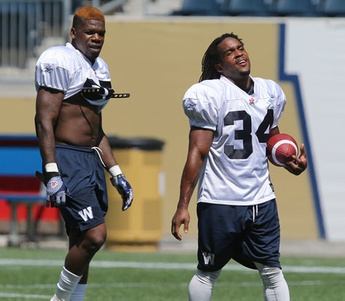 Winnipeg Blue Bombers RB Paris Cotton (right) and RB Kevin Smith warm up during football practice at Investors Group Field on Thurs., May 29, 2014. Photo by Jason Halstead/Winnipeg Free Press