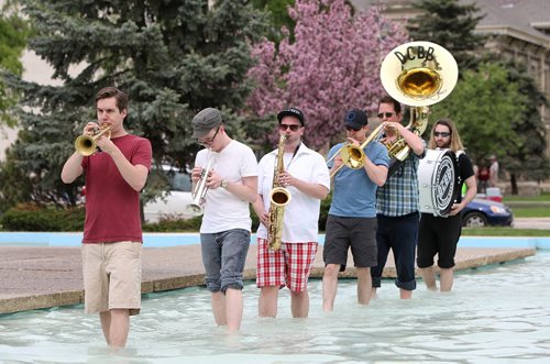 From left, members of the Dirty Catfish Brass Band, Andrew Littleford (trumpet), Simon Christie (trumpet),  Kyle Wedlake (tenor saxophone), Joel Green (trombone), Steve Oberheu (sousaphone) and Aaron Chodirker (drums), practise while strolling through the Memorial Park fountain on Sat., May 31, 2014. The band is practising for its debut album release show on June 28 at the West End Cultural Centre. STANDUP Photo by Jason Halstead/Winnipeg Free Press
