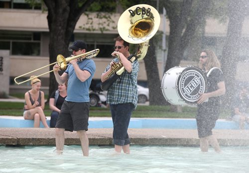 From left, members of the Dirty Catfish Brass Band, Joel Green (trombone), Steve Oberheu (sousaphone) and Aaron Chodirker (drums), practise while strolling through the Memorial Park fountain on Sat., May 31, 2014. The band is practising for its debut album release show on June 28 at the West End Cultural Centre. STANDUP Photo by Jason Halstead/Winnipeg Free Press