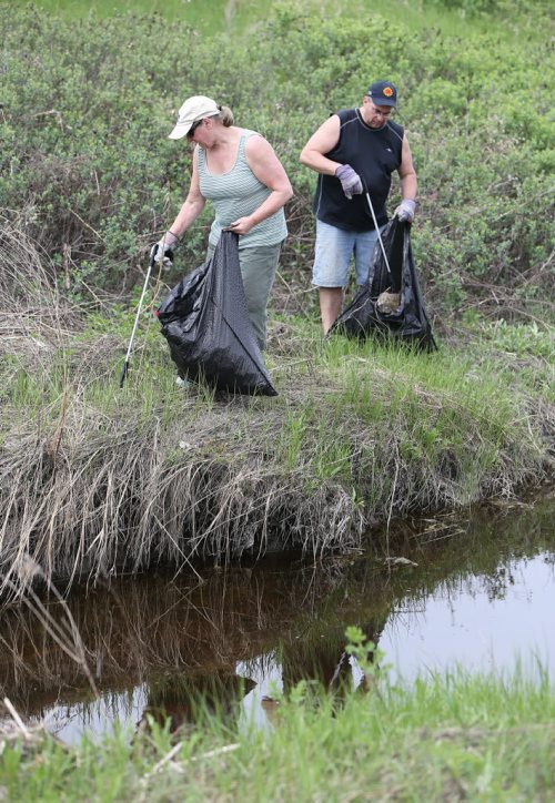 Peter Heese and Gail Archer-Heese pick up trash along OmandÄôs Creek near St. Matthews Avenue and Empress Street on Sat., May 31, 2014. It was part of the Creek Clean-up event of OmandÄôs, Truro and Sturgeon creeks, led by area¬MLAs. Volunteers spent several hours picking up and bagging trash before being treated to a barbecue. STANDUP Photo by Jason Halstead/Winnipeg Free Press
