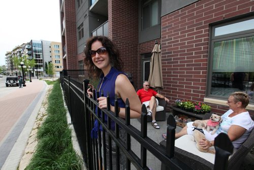 Jenna McMahon, looks over her patio railing from her condo on  Waterfront Drive.  She says she loves living in the area.    Feature story on Waterfront Blvd.   May 31, 2014 Ruth Bonneville / Winnipeg Free Press