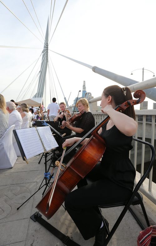 A string trio plays for diners at the Table for 1200 event on the Esplanade Riel Bridge on Sat., May 31, 2014. The event was an initiative of StorefrontMB and 5468796 Architecture, and was created to highlight Winnipeg's emerging design scene by bringing together architecture, design and the culinary arts. The prairie-themed food for the Äòpop upÄô outdoor dining experience was provided by local chefs Mandel Hitzer from Deer + Almond and Joe Kalturnyk from RAW Gallery, along with Ben Kramer from Diversity Food Services. Photo by Jason Halstead/Winnipeg Free Press