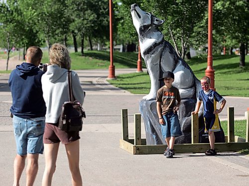 BORIS MINKEVICH / WINNIPEG FREE PRESS  070710 Tyler and Michelle Brown take pictures of their nephews from Edmonton Darien,8, and Keagan,5, with some of the new wolf statues at the forks.