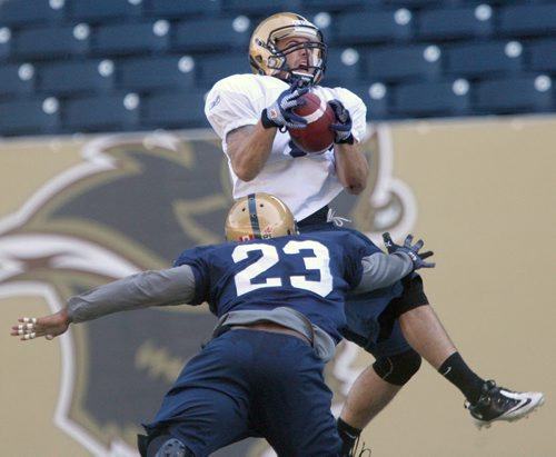Taylor Renuad grabs a pass while Desia Dunn defends during Winnipeg Blue Bomber training camp Wednesday morning at Investors Group Field- See Gary Lawless story- June 04, 2014   (JOE BRYKSA / WINNIPEG FREE PRESS)