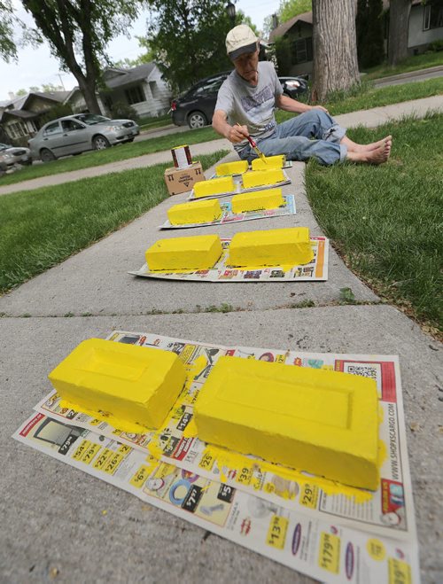 Garry Moir paints bricks yellow in front of his Wolseley home on Wed., June 4, 2014. He plans to use the bricks in a playground he is building for his three-year-old granddaughter in Snowflake, Man. STANDUP Photo by Jason Halstead/Winnipeg Free Press