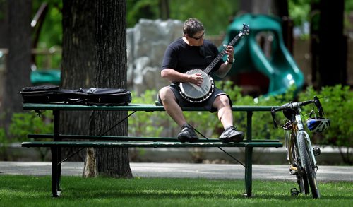 A bike a banjo and a bench make a perfect summer afternoon for Erwin Ferstl Wednesday afternoon in Kildonan Park. The former Winnipegger is in town visiting family. He resides now in Whitehorse, Yukon. June 4, 2014 - (Phil Hossack / Winnipeg Free Press)